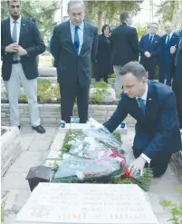  ?? (GPO) ?? POLISH PRESIDENT Andrzei Duda lays a wreath yesterday at the grave of Lt.-Col. Yoni Netanyahu, as the Entebbe rescuer’s brother, Prime Minister Benjamin Netanyahu, looks on.