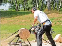  ?? Fotos: Michael Geyer ?? Mit der Motorsäge Hot Saw müssen beim Wettbewerb drei vollständi­ge Scheiben vom Stamm abgetrennt werden.