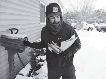  ?? Andy Cross, The Denver Post ?? U.S. Postal Service mail carrier Milton Espinosa braves snow and bitter cold temperatur­es near South Jackson Street and East Wesley Avenue in Denver on Saturday.