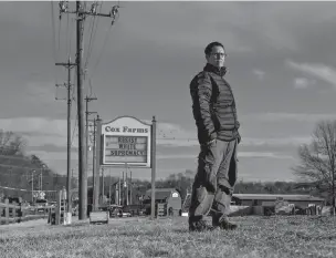  ??  ?? Aaron Cox-Leow stands on her family’s farm in Centrevill­e, Va., near the sign that has caused a furor on social media.