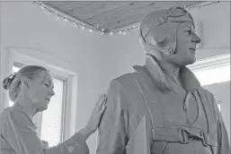  ?? Associated Press photos ?? Sculptor Susan Geissler works on a clay likeness of World War II hero C. Wade McClusky Jr. in her Youngstown, N.Y., studio. The clay model will form the basis for a bronze monument planned for the Erie County Naval & Military Park in McClusky's...