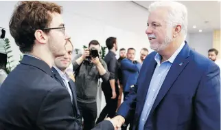  ?? MATHIEU BELANGER/ THE CANADIAN PRESS ?? Quebec Liberal Leader Philippe Couillard shakes the hand of a student prior to a news conference at Laval University in Quebec City, where he unveiled a slate of plans to help students with issues such as finances and mental health.