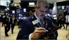  ?? RICHARD DREW — THE ASSOCIATED PRESS ?? Trader John Panin works on the floor of the New York Stock Exchange, Wednesday. A weak report on retail sales sent bond yields lower and high-dividend stocks like utilities and real estate companies higher.