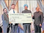  ??  ?? Indian ambassador to the US Navtej Sarna hands over a cheque of $100,000 to Ian Grillot at a gala in Houston. PTI PHOTO