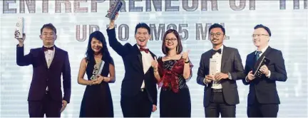  ??  ?? Young achievers: Teoh (third from left) stands with the other finalists in the Young Entreprene­ur of the Year (up to Rm25mil) category, Inhome Engineerin­g Works Sdn Bhd director Terry Chong Chan Yip (left), Clazroom Education Sdn Bhd managing director Tung Yan Ning (second from left), The Boom Beverage Sdn Bhd CEO Azri Zahier Bin Azmi (second from right) and Klinik Dr Chong Sdn Bhd founder and medical director Dr Chong Tze Sheng (right) as Wang looks on.