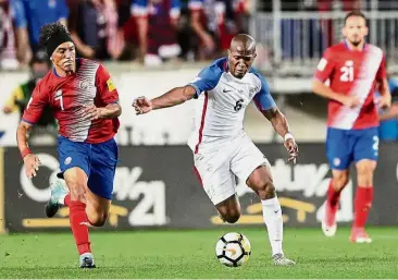  ??  ?? Full speed ahead: United States midfielder Darlington Nagbe (centre) dribbling past Costa Rica midfielder Cristian Bolanos at the Red Bull Arena on Friday. Costa Rica won 2- 0. — Reuters