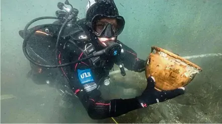  ??  ?? A diver holding an archaeolog­ical piece, recovered from the bottom of the Titicaca lake, near San Pedro de Tiquina in Bolivia. Thousands of priceless artefacts were discovered at the bottom of Titicaca, the highest navigable lake in the world. — AFP