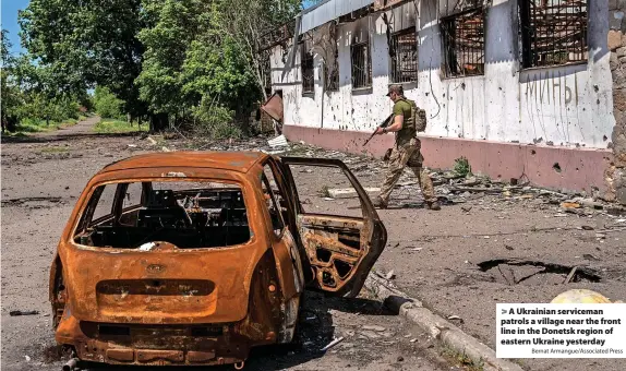  ?? Bernat Armangue/Associated Press ?? A Ukrainian serviceman patrols a village near the front line in the Donetsk region of eastern Ukraine yesterday