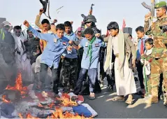  ?? ?? Protesters burn the flags of the United States and Israel in Sanaa, Yemen