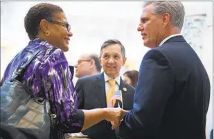 ?? Tom Williams CQ-Roll Call ?? REPS. KAREN BASS (D-Los Angeles) and Kevin McCarthy (R-Bakersfiel­d) talk as Rep. Dennis Kucinich (D-Ohio) looks on before a 9/11 remembranc­e ceremony on Sept. 11, 2012.