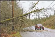  ?? AP/The Olympian/STEVE BLOOM ?? Caution tape marks the area around a downed tree Sunday near Nisqually, Wash. Windstorms battered parts of the state Saturday, leaving hundreds of thousands of people without power.