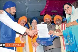  ?? —DC ?? From Left: Gurcharan Singh Bagga, president, Telangana Sikh Welfare Associatio­n, is handed over land documents for building a Gurudwara in Narsinghi by Mr Hardeep Singh Puri, Union minister of state with independen­t charge in the ministry of housing...