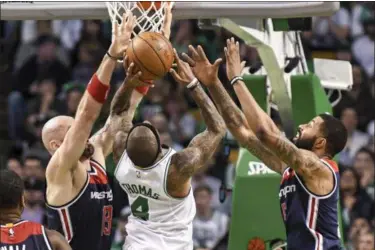  ?? THE ASSOCIATED PRESS FILE ?? Wizards defenders Marcin Gortat, left, and Markieff Morris contest a shot by Celtics guard Isaiah Thomas.