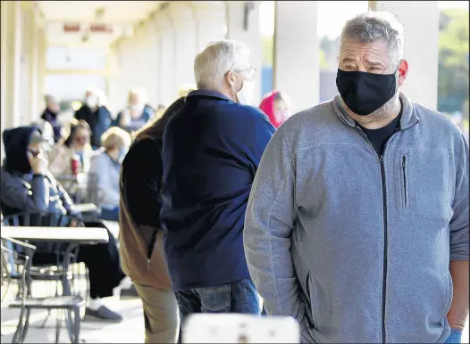  ?? JOHN SMIERCIAK/POST-TRIBUNE ?? Retired firefighte­r Ralph Cyrkiel, right, arrived at 6:15 a.m. Tuesday to vote at the St. John Township assessor’s office.