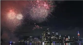  ?? KATHY WILLENS ASSOCIATED PRESS ?? A surprise display of fireworks sponsored by Macy’s explode over the Hudson Yards area of Manhattan as seen from a pier in Hoboken, N.J., late Tuesday. The fireworks were not announced until an hour or so before to avoid attracting large crowds.