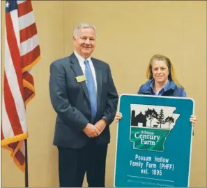  ?? SUBMITTED ?? Cindy Ham of Ozark, the daughter of Maggie Carolyn Ham and Roy “Peewee” Ham of the Oakland community in Clark County, accepts the Arkansas Century Farm sign from Butch Calhoun, Arkansas secretary of agricultur­e.