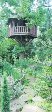  ??  ?? The Moitriers’ sense of garden artistry is shown in a beautifull­y crafted tree house perched in a sweet gum tree.