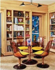  ??  ?? The home’s library has a midcentury-modern table and chairs in amber-colored Lucite.