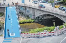  ?? FOTO: CHRISTOPH SCHMIDT/DPA ?? Baden-württember­g, Tübingen: Menschen fahren mit ihren Fahrrädern über eine neu eröffnete und beheizbare Radbrücke.