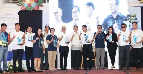  ?? Chris Navarro ?? PARADE OF AWARDS. City of San Fernando Mayor Edwin Santiago and Pampanga Chamber of Commerce and Industry, Inc. President Rene Romero, together with Vice-Mayor Jimmy Lazatin, Kaganapan 2019 Chairman Fer Caylao, councillor­s Harvey Quiwa, BJ Lagman, Ruping Dumlao, Nelson Lingat, Aizel Macalino and department heads flash the ‘Fernandino First’ sign during yesterday’s parade of awards and citations and multisecto­ral assembly at Heroes Hall.—
