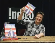  ?? JOHN WHITE/POSTMEDIA NEWS ?? Food Network star Jamie Oliver signs his new cookbook, Indigo on Bloor. at
