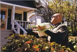  ?? A CITY WORKER Genaro Molina Los Angeles Times ?? delivers a compost pail to a resident in Los Feliz in August.