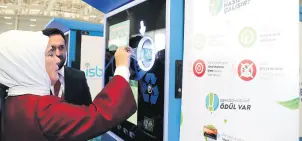  ??  ?? First lady Emine Erdoğan deposits a plastic bottle into a recycling machine in Istanbul, where commuters get transport credits in return for each bottle deposited, Dec. 10, 2018.