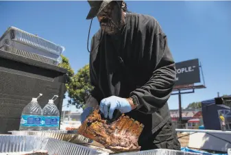  ?? Jessica Christian / The Chronicle ?? Harold Agee cooks up ribs and hot links for customers of his popup Big H BBQ at the Bayview Bistro food truck park, a temporary setup on a slice of undevelope­d urban land.