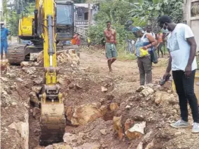  ??  ?? Councillor Anthony Murray (right), Jamaica Labour Party, Rose Hall Division, and residents of Grange Pen, St James, peer into the trench from which the body of Catherine Powell was recovered yesterday morning.