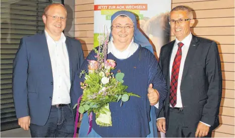  ?? FOTO: ZURKE ?? Neresheims Bürgermeis­ter Thomas Häfele (links) und Josef Bühler, Geschäftsf­ührer der AOK Ostwürttem­berg, begrüßen Schwester Teresa Zukic in ihrer Mitte.