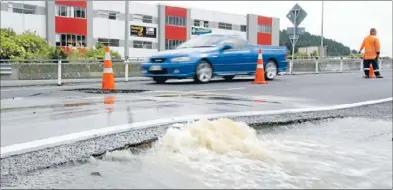  ?? Photo: KEVIN STENT ?? Flooded: A burst water main in State Highway 1 near the Plimmerton weighbridg­e closed a lane last week. It took about two hours to locate the faulty valve and turn it off.