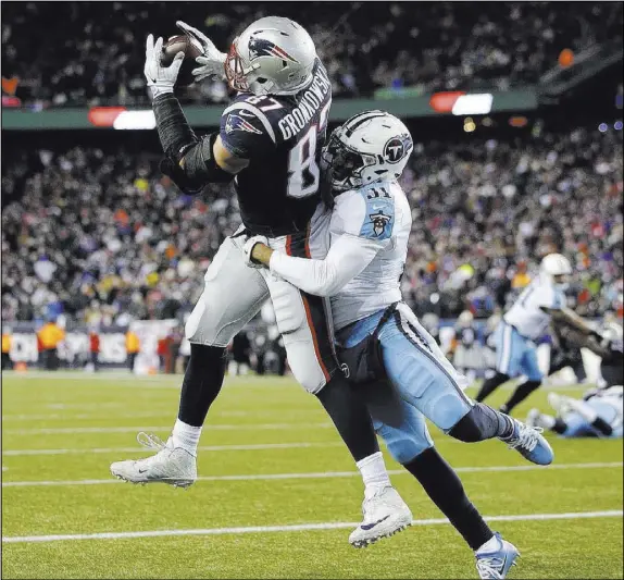  ?? Steven Senne The Associated Press ?? New England Patriots tight end Rob Gronkowski hauls in a touchdown pass with Tennessee Titans safety Kevin Byard defending in an AFC divisional playoff game Jan. 13 in Foxborough, Mass.