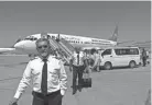  ?? WALI SABAWOON/AP ?? Pilots of Ariana Afghan Airlines walk on the tarmac after landing at Hamid Karzai Internatio­nal Airport in Kabul, Afghanista­n, on Sunday. Some domestic flights have resumed at Kabul’s airport.