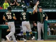  ?? AP Photo /Roger Steinman ?? In this July 24 file photo, Oakland Athletics manager Bob Melvin, right, gives Khris Davis (2) a high-five after Davis’ three-run home run in the 10th inning of a baseball game against the Texas Rangers in Arlington, Texas.