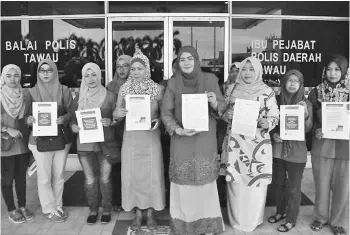  ??  ?? Nazliah (fourth right) with Zakiah (third right) and Tawau Puteri Umno members yesterday after making a police report against lies made viral on social media.