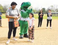  ?? PAULW. GILLESPIE/ CAPITAL GAZETTE ?? Baysox Community Programs Manager Kelsey Carter, left, presents fourth grader Annie Mejia, with a gift April 12 after she won the contest to design a Baysox jersey to be worn by the team for five games this season.