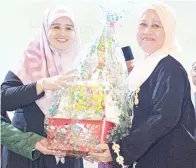  ??  ?? NURLAILA sekolah. menyampaik­an sumbangan kepada wakil