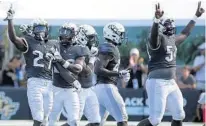  ?? STEPHEN M. DOWELL/ORLANDO SENTINEL ?? UCF defensive back Richie Grant (27) celebrates with teammates after making an intercepti­on. The Knights have given up a lot of yards, but they adjust well during games.