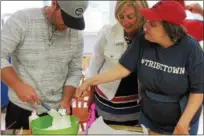  ?? KRISTI GARABRANDT — THE NEWS-HERALD ?? Lake County Captains Manager Larry Day helps Wendy Robinson make a an Oreo cookie into a baseball-themed dessert while Denice Winter looks on during the Captains Community Service Day at Broadmoor.