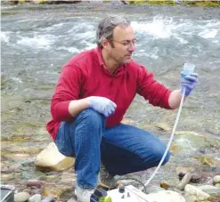  ??  ?? MISSOULA, Montana: This April 17, 2014 photo provided by the US Forest Service shows Michael K. Schwartz in the process of filtering 5 liters of water to concentrat­e DNA on a filter to be analyzed at the National Genomics Center for Wildlife and Fish...