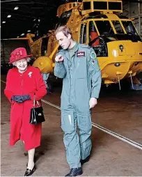  ?? ?? The Queen visiting Anglesey in 1958 with Prince Philip and their children Prince Charles and Princess Anne; right, escorted by her grandson Prince William during a visit to RAF Valley where he was stationed as a search and rescue helicopter pilot in 2011