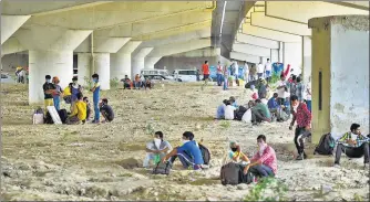  ?? AMAL KS/HT PHOTO ?? Migrants from other states rest under a flyover in Ghazipur on their journeys back to their hometowns. n