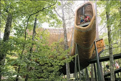  ?? Arkansas Democrat-Gazette/THOMAS METTHE ?? Josh McGriff of Star City and his son, Judd, 2, check out the view from the top during the soft opening of the treehouse at Garvan Woodland Gardens in Hot Springs on Saturday. More photos are available at arkansason­line.com/galleries.