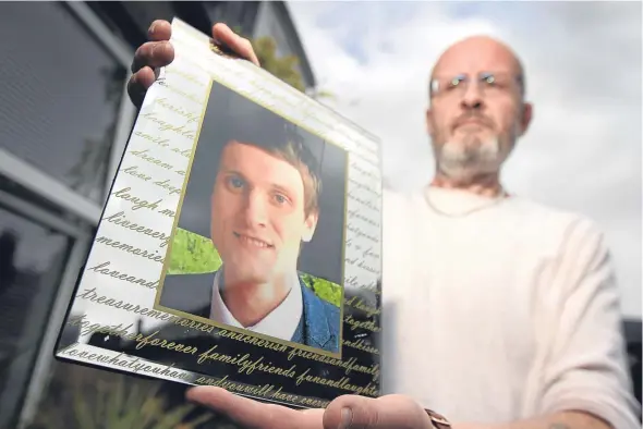  ??  ?? Phil Welsh holding a photograph of his son Lee, who died last month.
