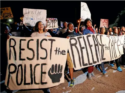  ?? REUTERS ?? Protesters march during another night of demonstrat­ions yesterday over the police shooting of Keith Scott in Charlotte, North Carolina.