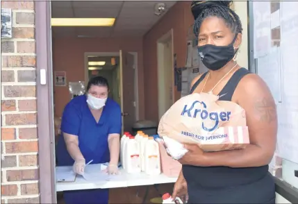  ?? GINA JOSEPH — THE MACOMB DAILY ?? Among those delivering hot meals to low-income families during the pandemic is Erika Bradbury, left, with Macomb County Rotating Emergency Shelter Team (MCREST). In August, MCREST received a $50,000grant to carry on its mission to help the county’s homeless population during the pandemic and in the future.