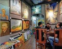 ?? PHOTOS BY ZHANG WEI / CHINA NEWS SERVICE ?? Zhao Xiaoyong (center), farmer-turned-painter in Dafen village, Shenzhen, Guangdong province, has shifted his focus from duplicatin­g to creating his own artworks.