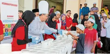  ??  ?? > SEE NEXT PAGE
Tan Sri Razman Hashim, Sunway Group deputy chairman distributi­ng bubur lambuk to B40 community.