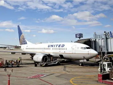  ??  ?? HOMECOMING­S A United jet (left) on the ground in Chicago. (Above) Deportees cover their faces after arriving in Guatemala City on November 21, 2019.