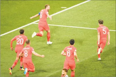  ?? Nicolas Asfouri / Getty Images ?? England forward Harry Kane, top, celebrates after scoring his first goal during the World Cup Group G match against Tunisia on Monday in Volgograd, Russia. Kane later scored the game winner for England, which prevailed over the Tunisians 2-1.